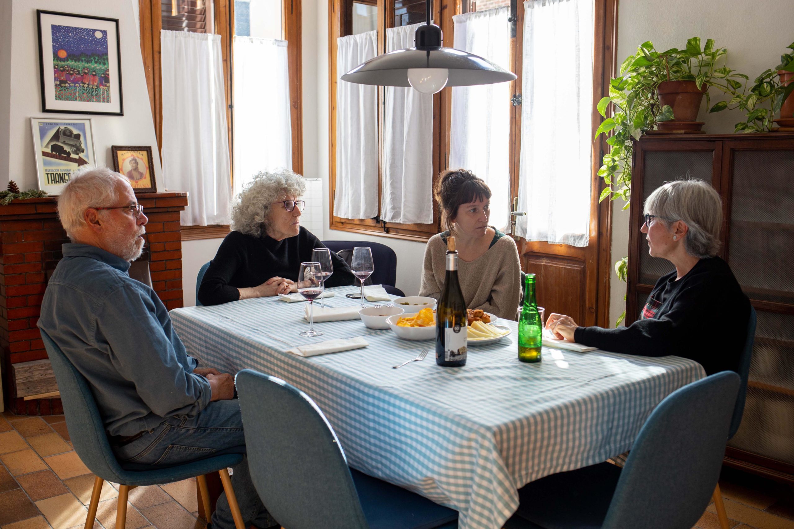 Vista general d'un dinar d'un grup d'amigues assegudes a la taula del menjador de casa