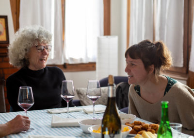 Dues dones rient en un dinar en un menjador de casa