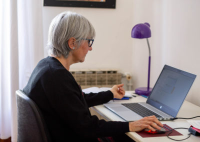 Dona asseguda escrivint a l'ordinador en un despatx