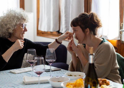 Dues dones agafades fent un gest carinyós en un dinar al menjador de casa