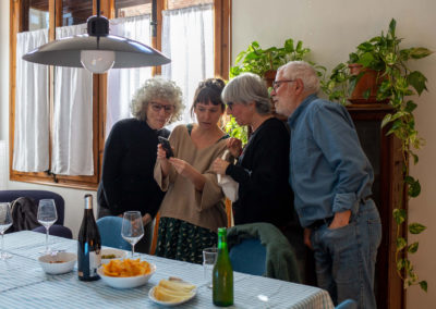 Vista general d’un grup d’amigues mirant el mòbil juntes al menjador de casa