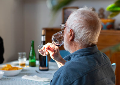 Home prenent una copa de vi en un dinar al menjador de casa