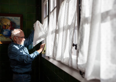Home netejant vidres a la cuina de casa