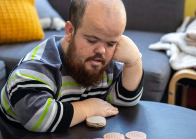 Un noi pensant mentre juga a un joc de taula