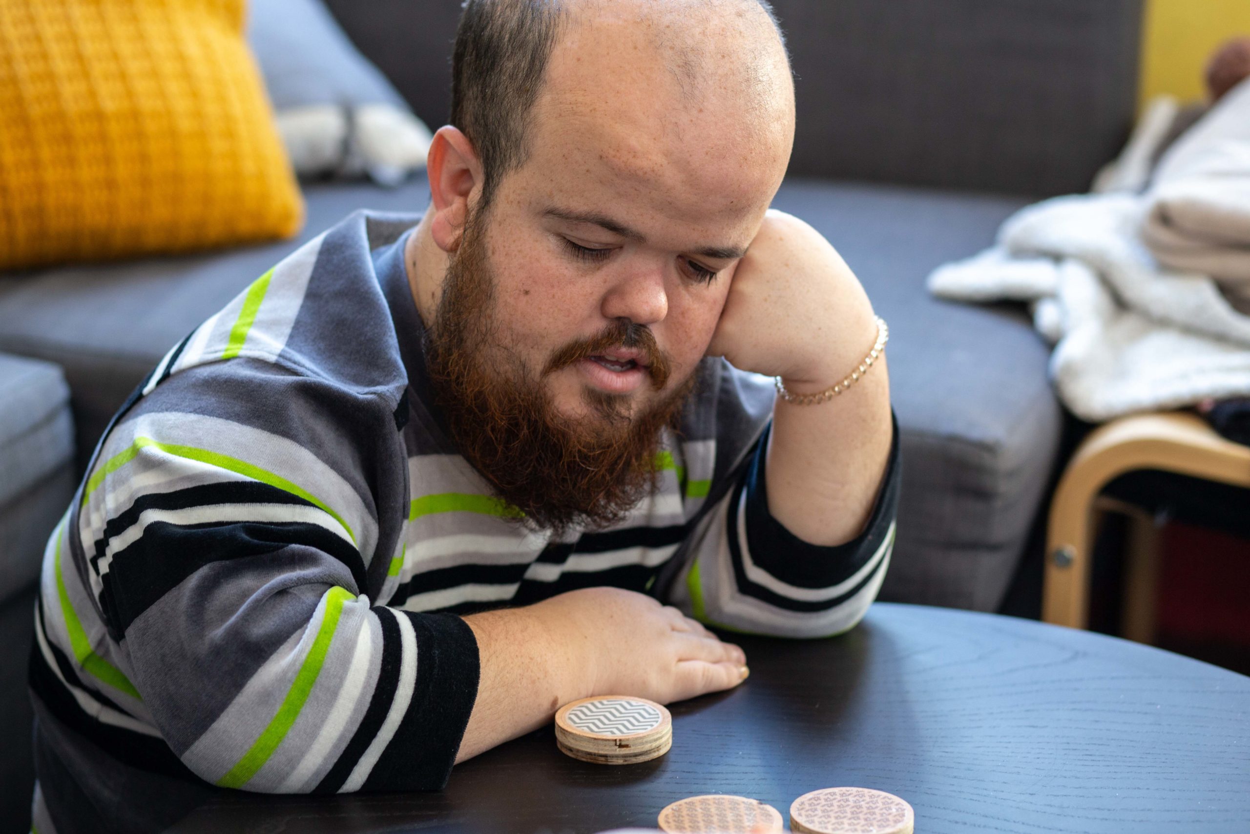 Un noi pensant mentre juga a un joc de taula al menjador