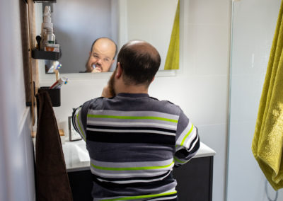 Un noi es raspatlla les dents mentre es mira al mirall del lavabo