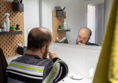 Un noi es raspatlla les dents mentre es mira al mirall del lavabo