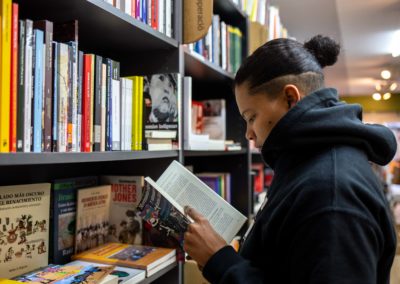 Noia llegint a llibreria